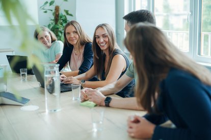 Fünf Mitarbeitende von HMS stimmen sich gemeinsam zu einer Projektaufgabe in einem Meeting ab.