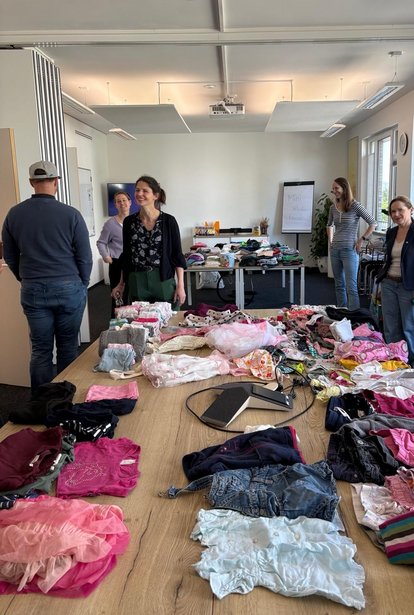 Mitarbeitende beim HMS Mini-Kleidertausch für gebrauchte Kinderkleidung.